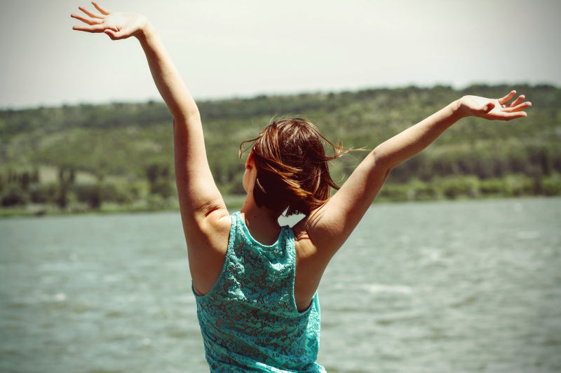 Person with arms raised in freedom